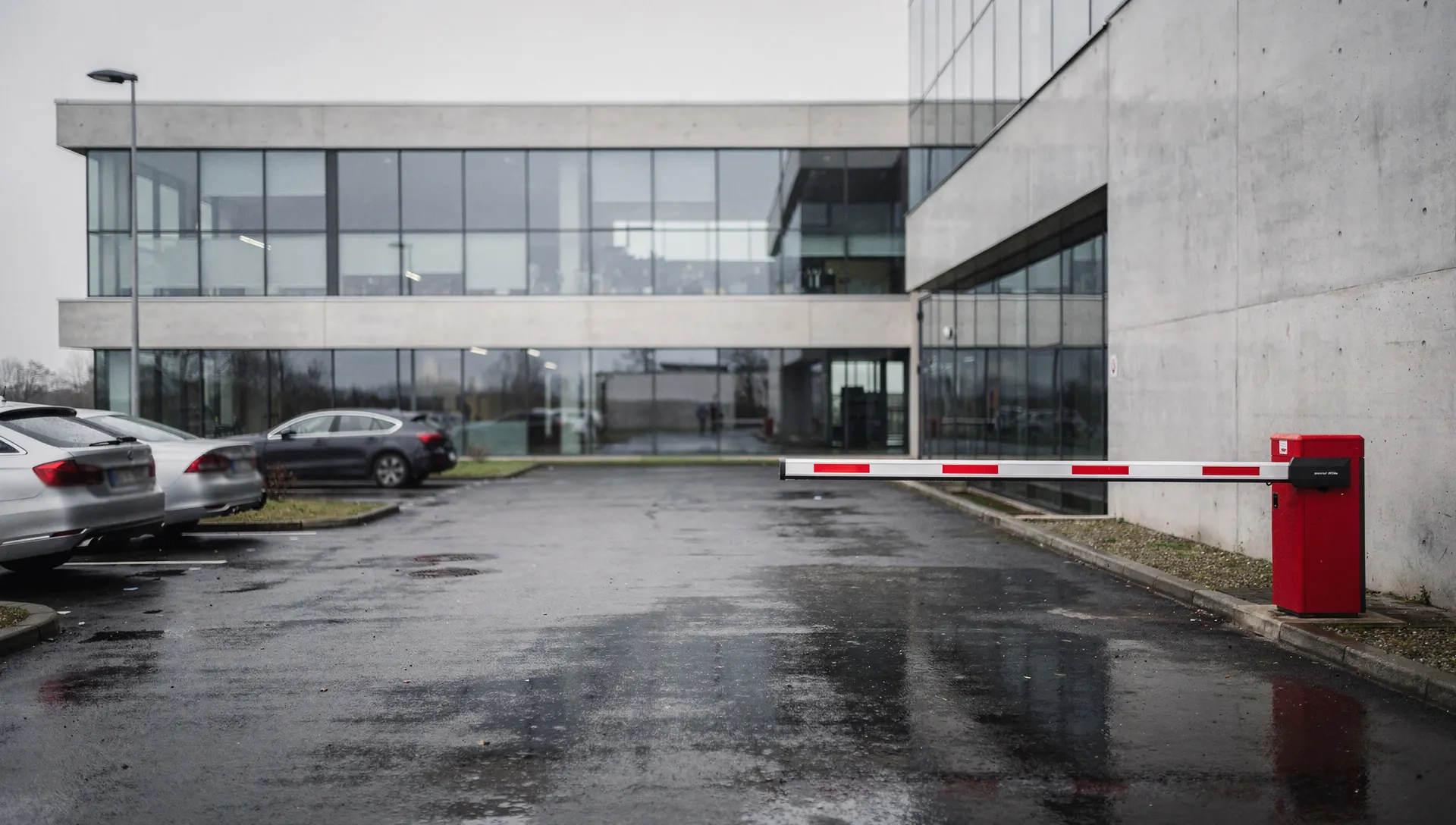 Wjazd na parking biurowca zamknięty szlabanem.